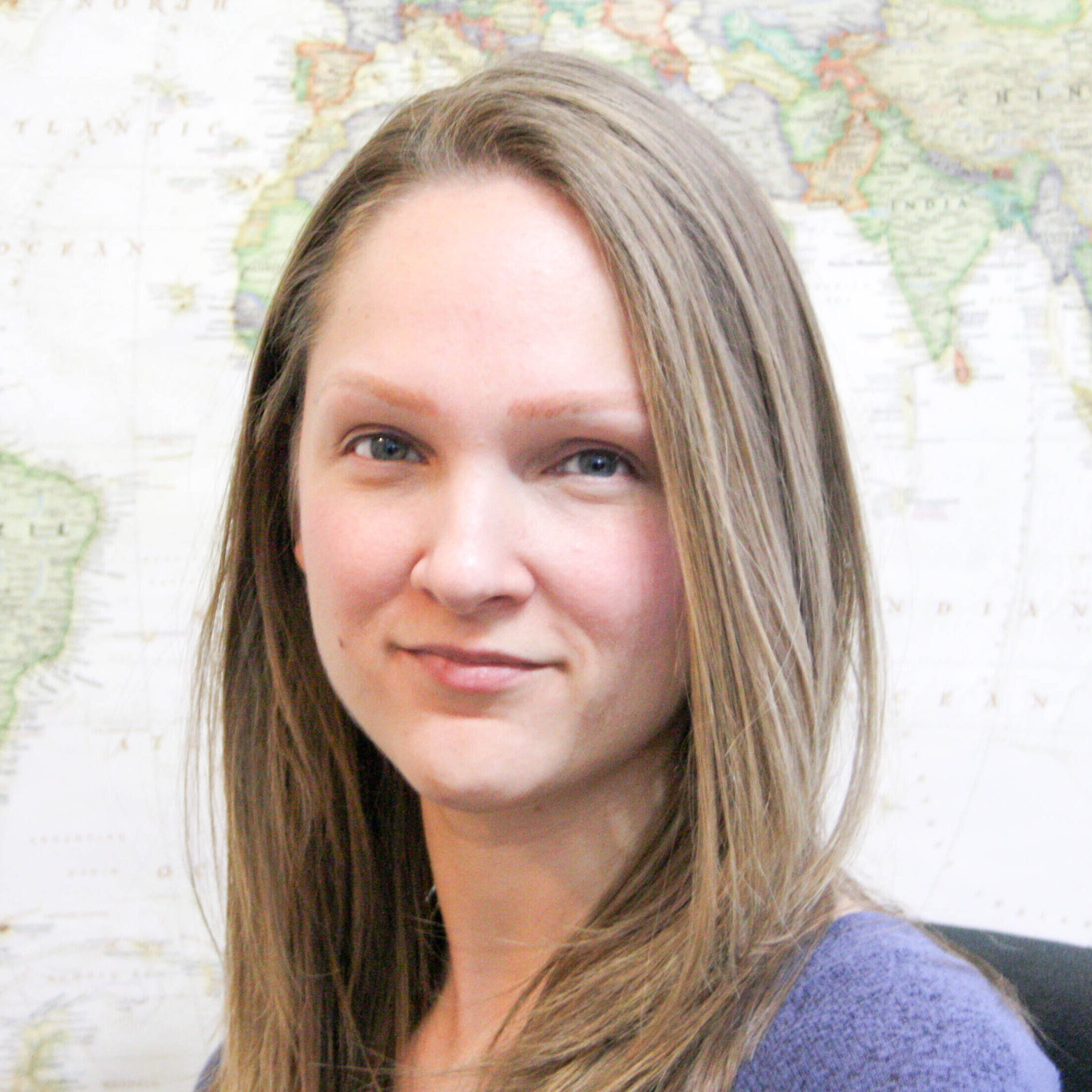 a woman with long hair in front of a world map